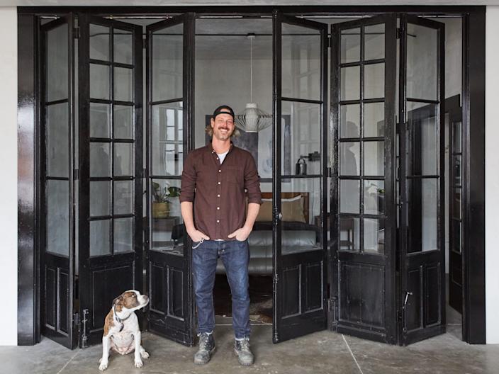 Steve Ford in front of windows and with a dog